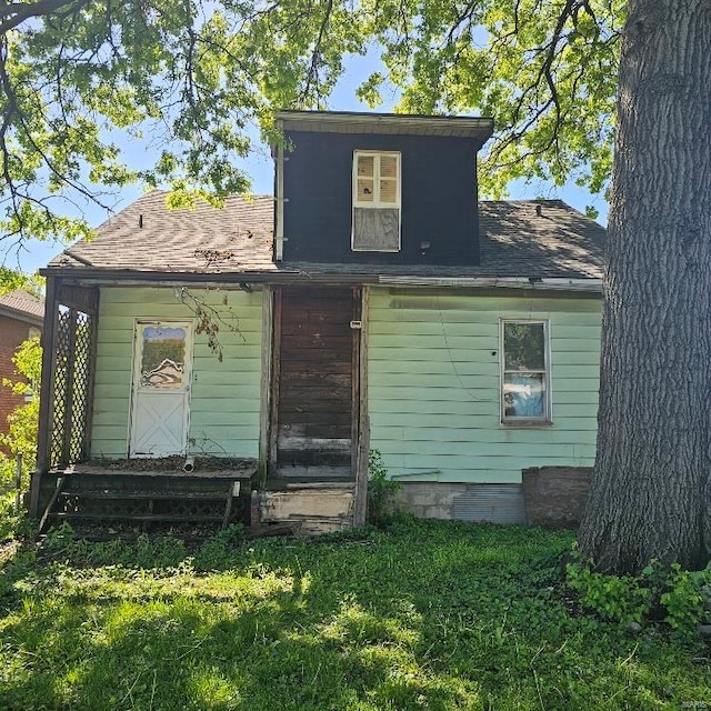 rear view of house featuring a lawn