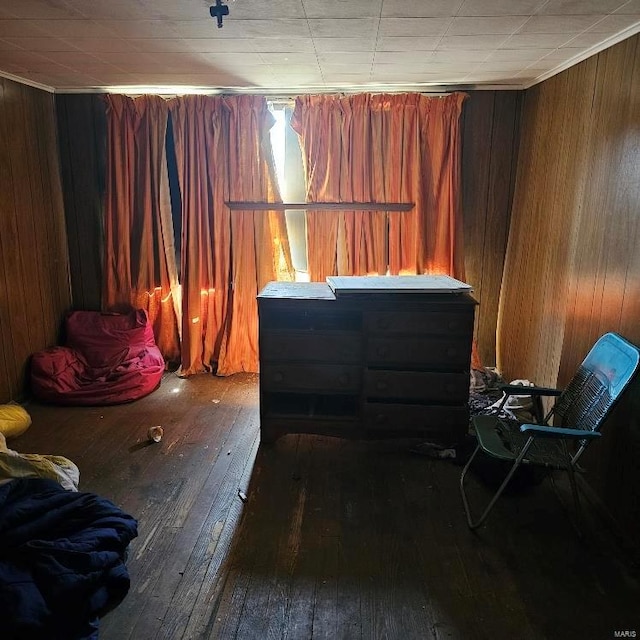 bedroom featuring hardwood / wood-style flooring and wooden walls