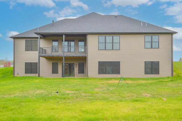 rear view of property with a lawn and a balcony