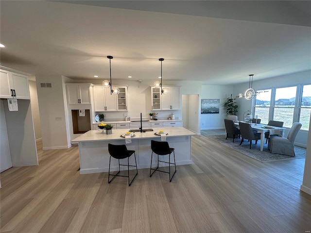 kitchen with visible vents, light wood-style flooring, and white cabinets