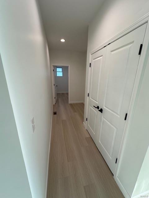 hallway featuring recessed lighting, baseboards, and light wood-style floors