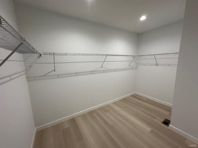 spacious closet featuring visible vents and wood finished floors