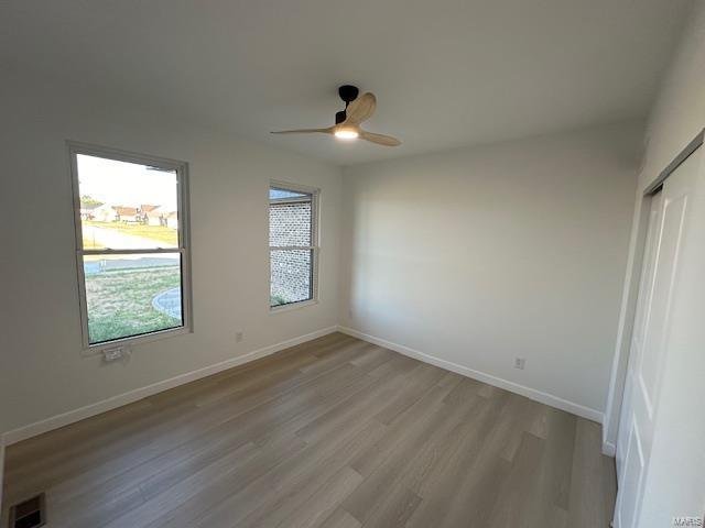 unfurnished bedroom with visible vents, baseboards, and light wood-style floors