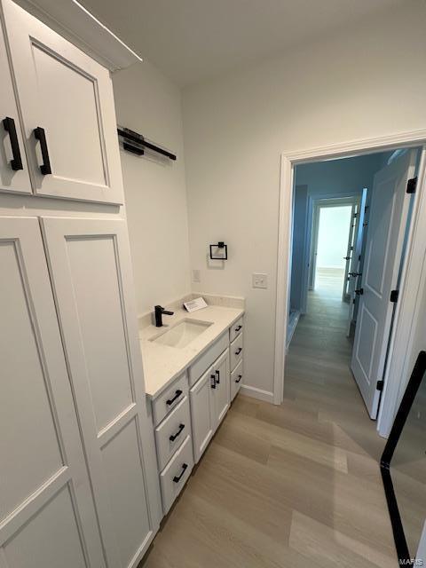 bathroom featuring vanity, baseboards, and wood finished floors