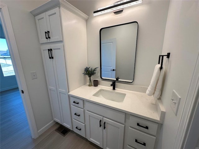 bathroom with visible vents, baseboards, wood finished floors, and vanity