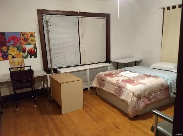 bedroom featuring light hardwood / wood-style floors and radiator heating unit