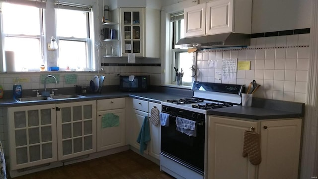 kitchen with sink, white range with gas cooktop, tasteful backsplash, and white cabinetry