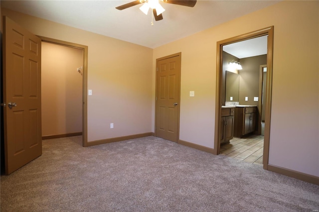 unfurnished bedroom with a closet, ceiling fan, carpet, and ensuite bathroom