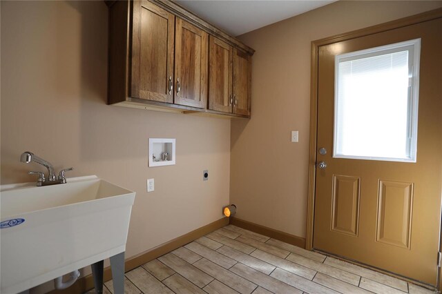 washroom with plenty of natural light, cabinets, hookup for an electric dryer, and sink