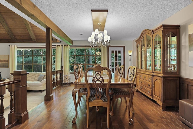 dining area featuring beam ceiling, dark wood-type flooring, and a notable chandelier