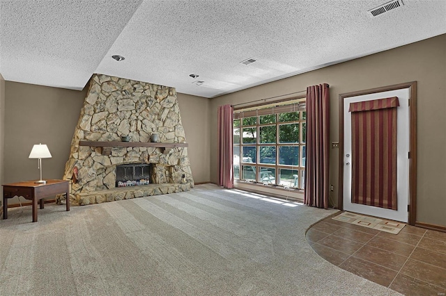 unfurnished living room with carpet flooring and a stone fireplace