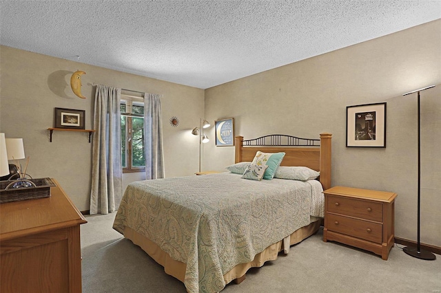 bedroom with light carpet and a textured ceiling