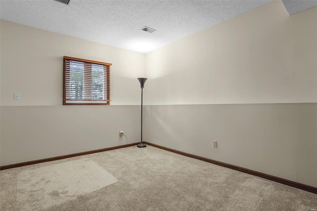 carpeted spare room with a textured ceiling