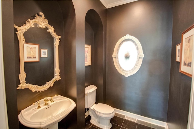 bathroom with sink, toilet, tile floors, and crown molding