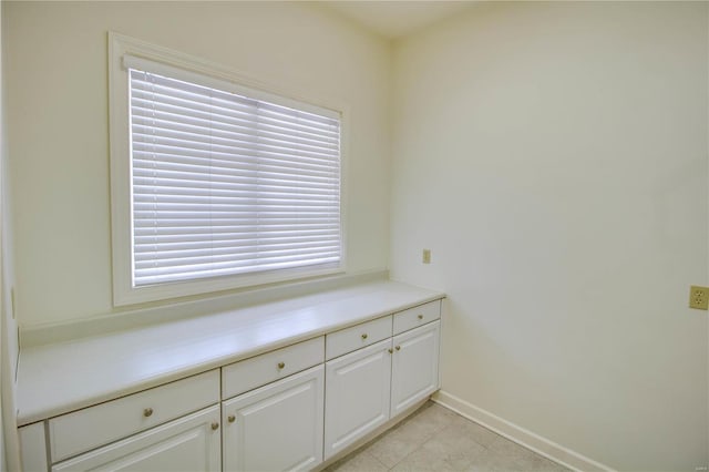 laundry area with plenty of natural light and light tile flooring