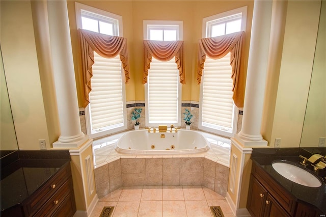 bathroom featuring tile flooring, decorative columns, tiled bath, and vanity