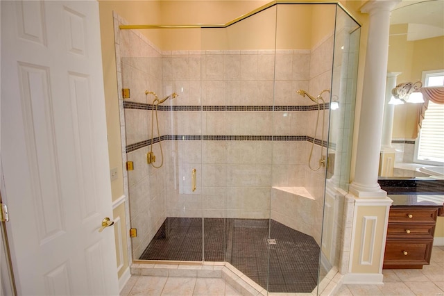 bathroom with tile flooring, an enclosed shower, vanity, and decorative columns