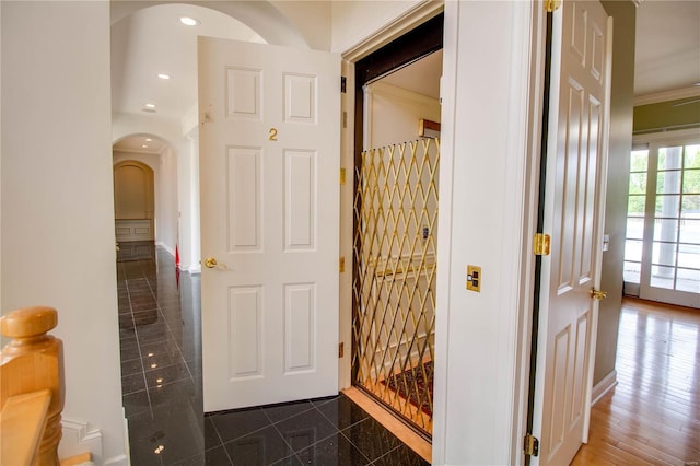 hall with dark hardwood / wood-style flooring and crown molding