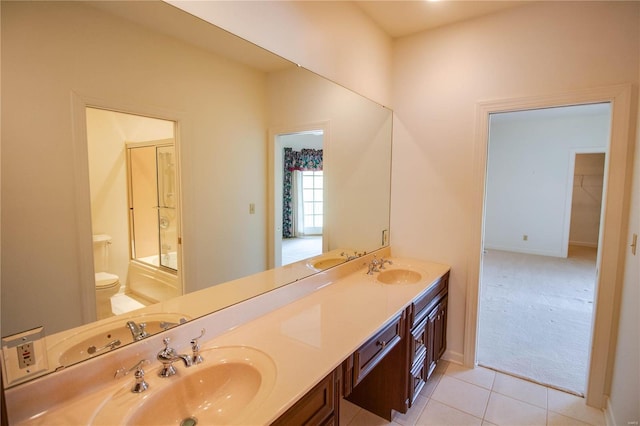 bathroom featuring tile flooring, dual sinks, toilet, and large vanity