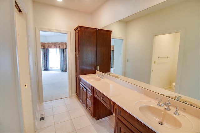 bathroom featuring dual bowl vanity, toilet, and tile floors