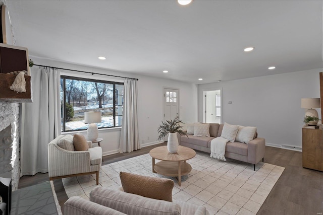 living room featuring a stone fireplace and light hardwood / wood-style floors