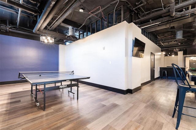 game room featuring hardwood / wood-style flooring and a high ceiling