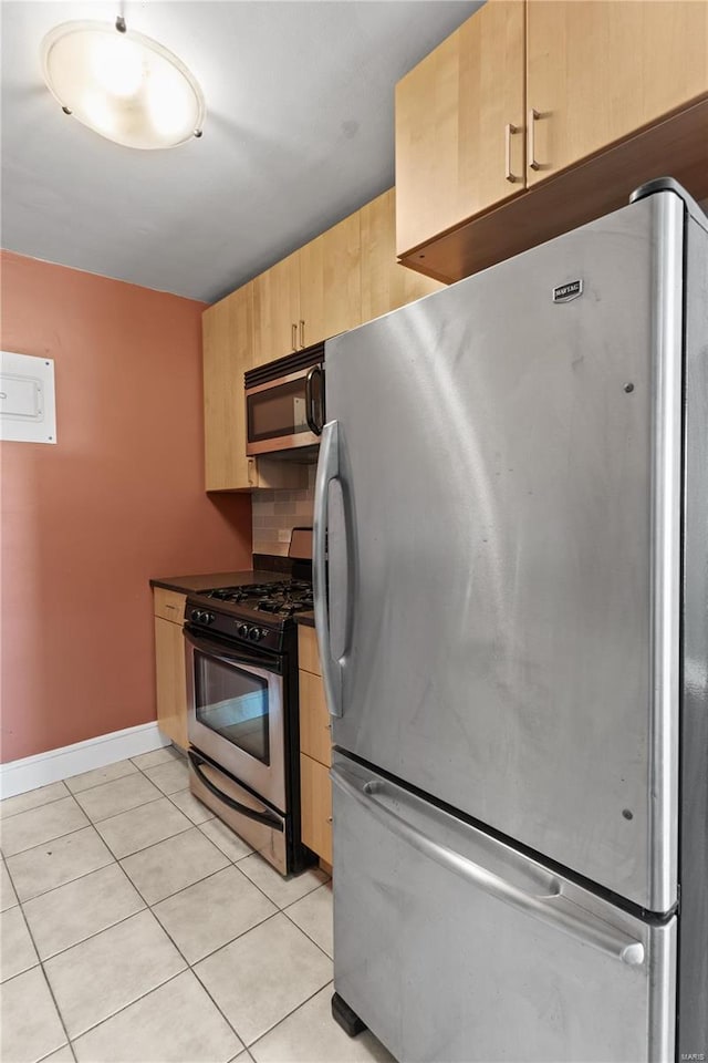 kitchen featuring light brown cabinets, decorative backsplash, light tile patterned floors, and stainless steel appliances