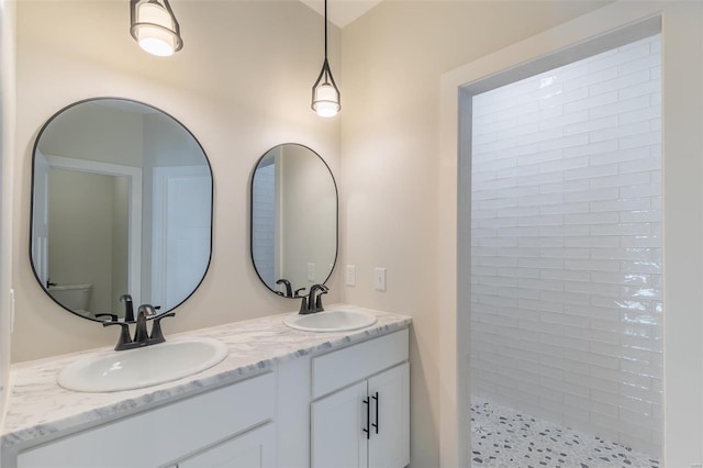 bathroom with vanity and tiled shower