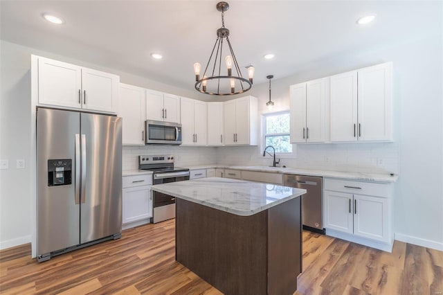 kitchen featuring a kitchen island, dark hardwood / wood-style flooring, a chandelier, and stainless steel appliances