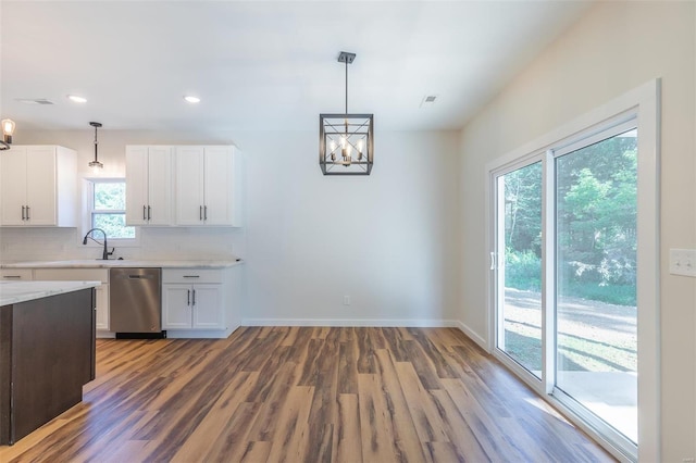 kitchen featuring white cabinets, dishwasher, pendant lighting, and hardwood / wood-style floors