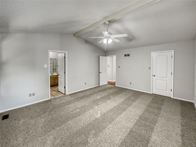 carpeted spare room with ceiling fan and vaulted ceiling with beams