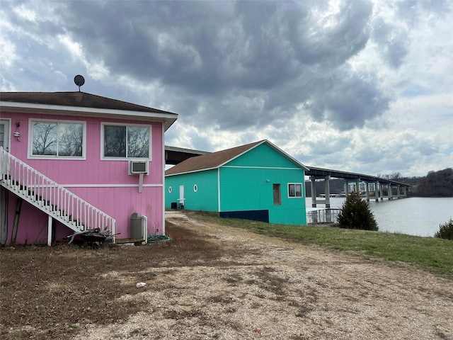 rear view of property with an AC wall unit