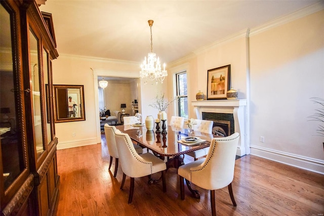 dining room with an inviting chandelier, wood-type flooring, and ornamental molding