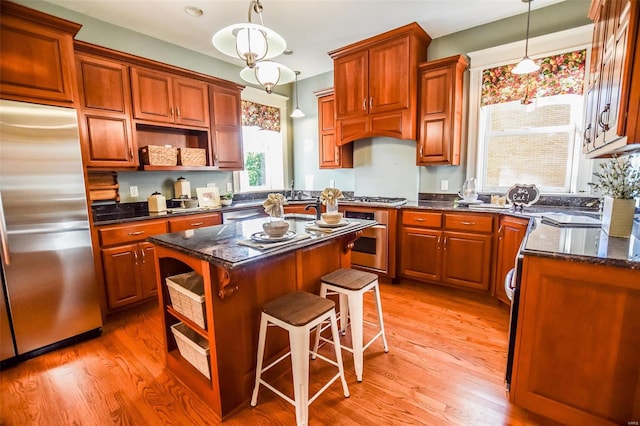 kitchen featuring stainless steel appliances, hardwood / wood-style floors, pendant lighting, a breakfast bar, and a kitchen island