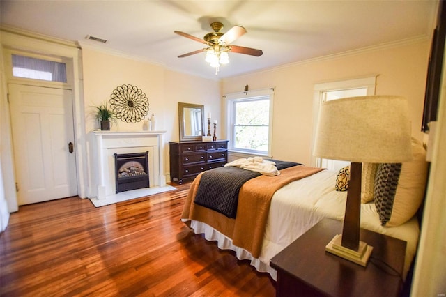 bedroom featuring hardwood / wood-style floors, ceiling fan, and ornamental molding