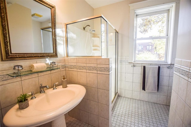 bathroom featuring walk in shower, tile walls, and sink