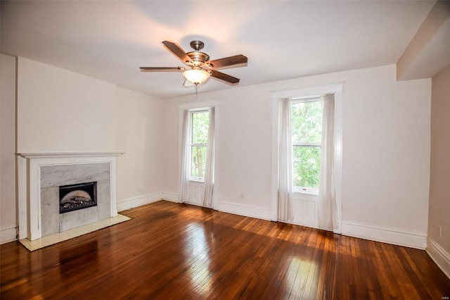 unfurnished living room featuring ceiling fan, a fireplace, and dark hardwood / wood-style floors