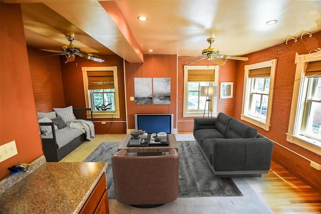 living room with hardwood / wood-style flooring, plenty of natural light, and wooden walls