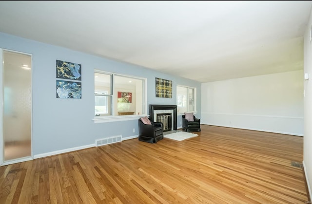 unfurnished living room featuring plenty of natural light and light wood-type flooring