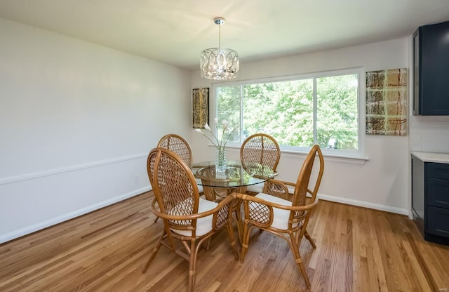 dining area featuring light hardwood / wood-style flooring and a chandelier