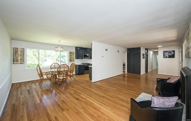 living room featuring light hardwood / wood-style floors and an inviting chandelier