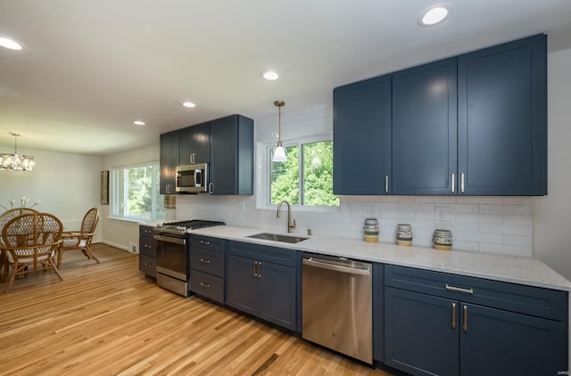 kitchen with appliances with stainless steel finishes, blue cabinets, and sink