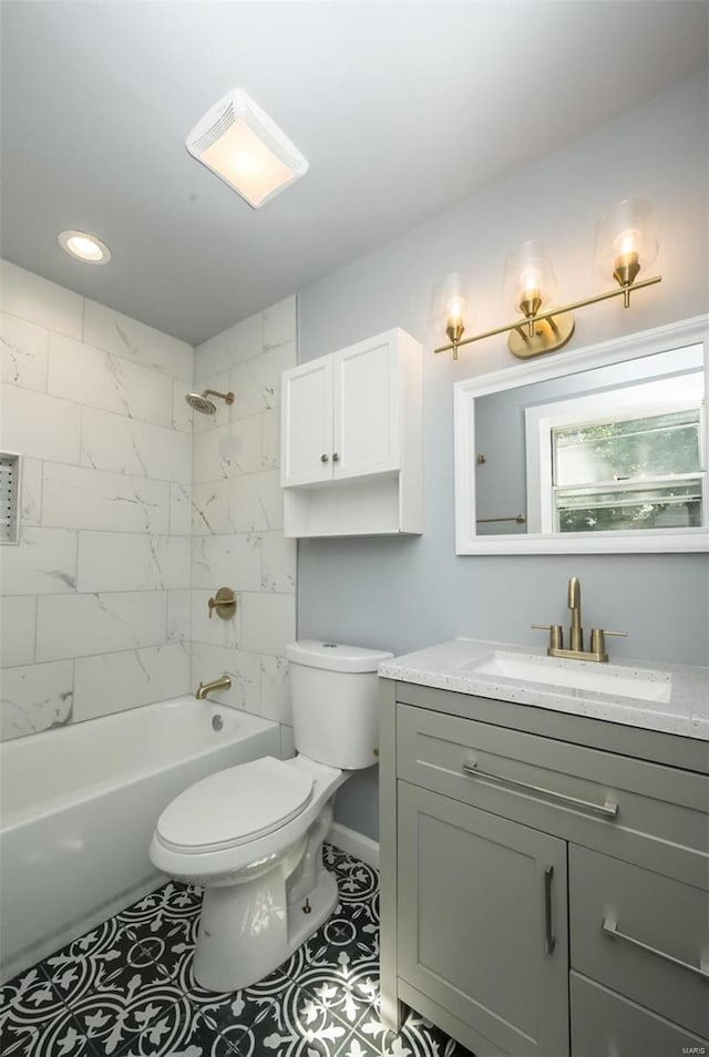 full bathroom featuring toilet, tile patterned flooring, vanity, and tiled shower / bath