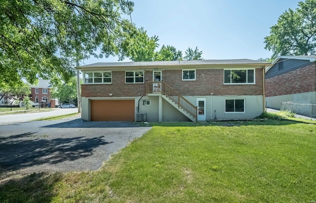 raised ranch with a garage and a front yard