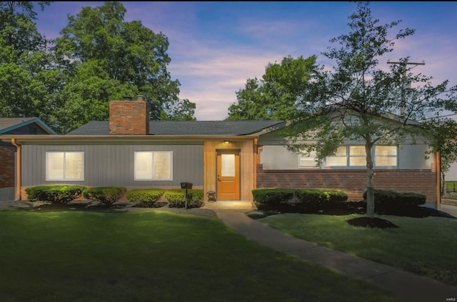 ranch-style home featuring a lawn