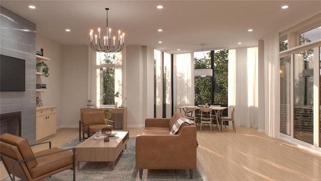 sitting room with a brick fireplace, a notable chandelier, and light wood-type flooring