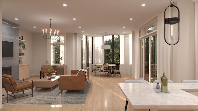 interior space with an inviting chandelier, a fireplace, and light wood-type flooring