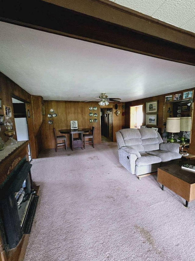 carpeted living room with wooden walls and ceiling fan