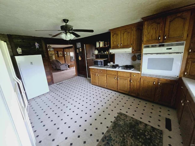 kitchen with appliances with stainless steel finishes, ceiling fan, light tile floors, and a textured ceiling