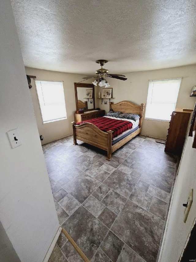 tiled bedroom with a textured ceiling and ceiling fan